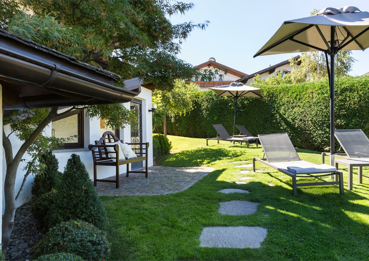 Giardino con sdrai e ombrelloni presso la struttura esterna Residence Mayr