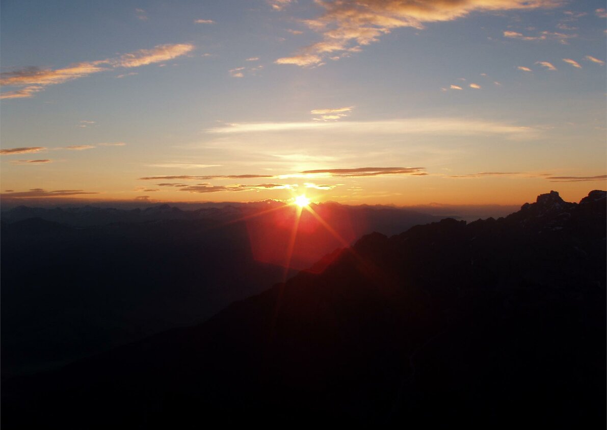 Primi sorgi di sole dalla cima dietro la casa